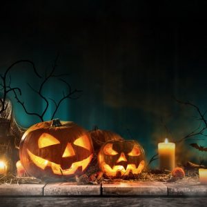 Halloween pumpkins on wooden planks with spooky background.